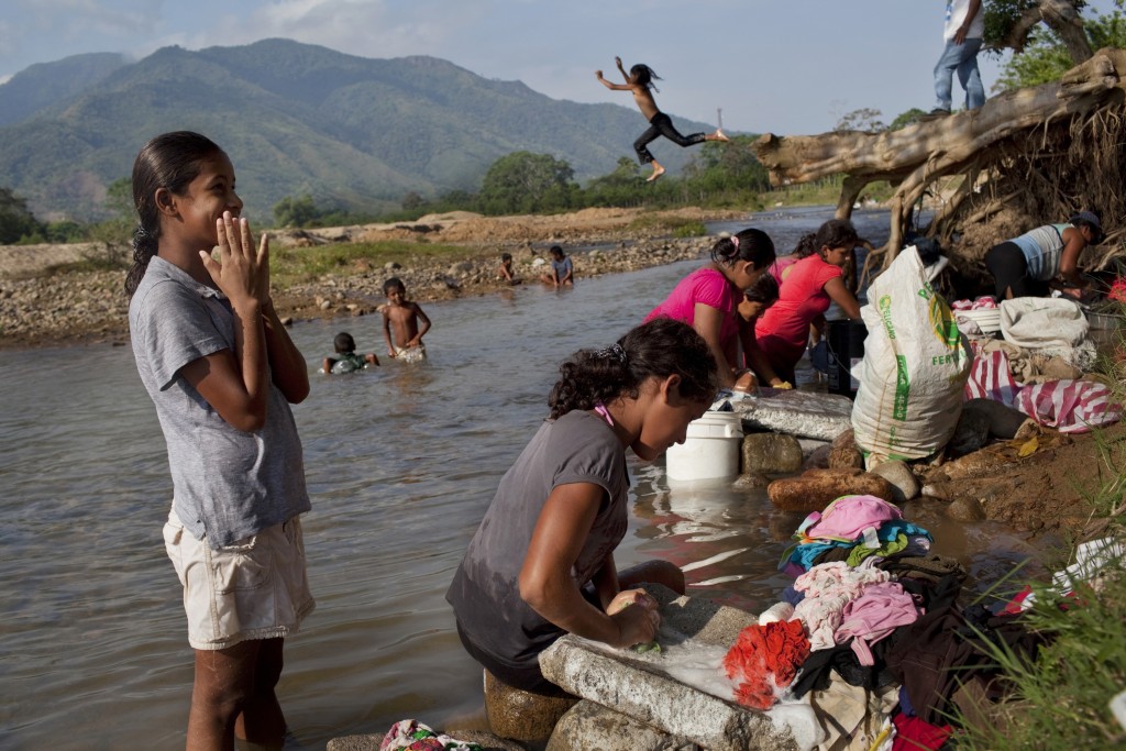 In this May 6, 2012 photo, women wash clothes in a river near "La Confianza" peasant model city, Bajo Aguan, Honduras. Peasants from MUCA (Movimiento Unificado Campesino del Bajo Aguan) occupied around 7000 sq meters of productive land close to the city of Tocoa in the Valley of Bajo Aguan, eastern coast of Honduras in December, 2009. They operate a comercial production of african palm and they also stablished what they call a "peasant model city" called "La Confianza" where more than 300 hundred families live. Since then an open conflict between them and the alleged owner of the land, Miguel Facussé, one of the most powerful businessmen in Honduras has left more than 60 people dead including peasants, security guards, a journalist and members of the Honduran national police. (AP Photo/Rodrigo Abd)